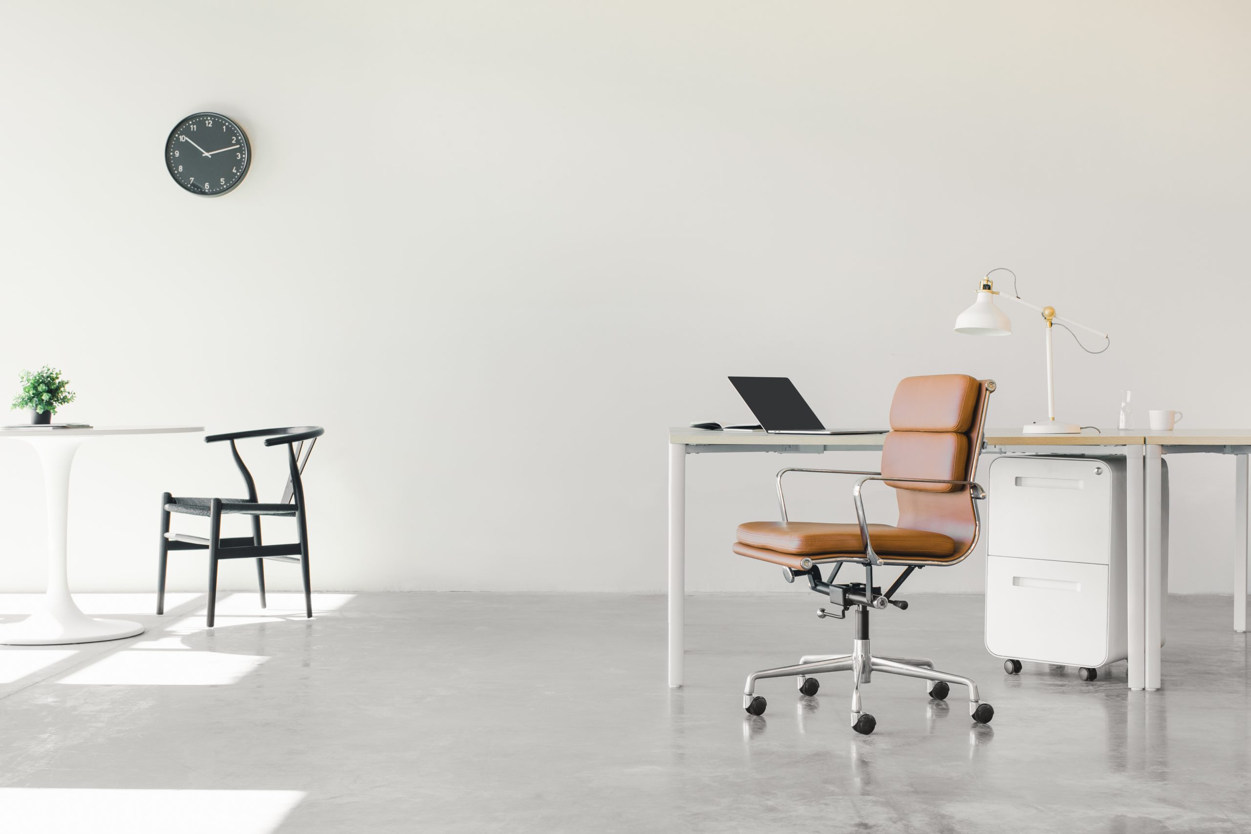An open floor plan office space with a minimalist setup of chairs and desks.